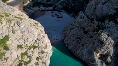 4K Hava Aracı 'nın eşsiz plaj videosu kanyona oyulmuş turkuaz mavi su ve demirli tekneler, Sa Calobra Plajı, Mallorca, İspanya