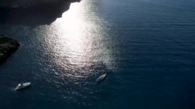 4K Hava Aracı 'nın eşsiz plaj videosu kanyona oyulmuş turkuaz mavi su ve demirli tekneler, Sa Calobra Plajı, Mallorca, İspanya