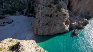 4K Hava Aracı 'nın eşsiz plaj videosu kanyona oyulmuş turkuaz mavi su ve demirli tekneler, Sa Calobra Plajı, Mallorca, İspanya