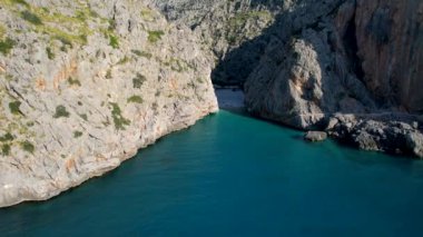 4K Hava Aracı 'nın eşsiz plaj videosu kanyona oyulmuş turkuaz mavi su ve demirli tekneler, Sa Calobra Plajı, Mallorca, İspanya