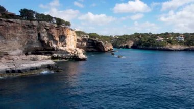 4K Hava Aracı 'nın eşsiz bir kaya oluşumunun videosu. Kayalıklardan ayrılan bir kemer. Yakınındaki turkuaz berrak mavi su ve plajla birlikte. Es Pontas, Mallorca