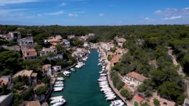 4K Hava Aracı, küçük bir balıkçı kasabasının videosu, kristal berrak turkuaz suyu olan balıkçı tekneleri, Cala Figuera, Mallorca