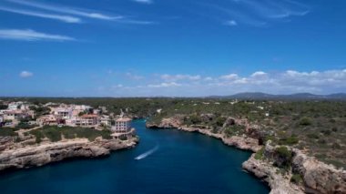 4K Hava Aracı, küçük bir balıkçı kasabasının videosu, kristal berrak turkuaz suyu olan balıkçı tekneleri, Cala Figuera, Mallorca