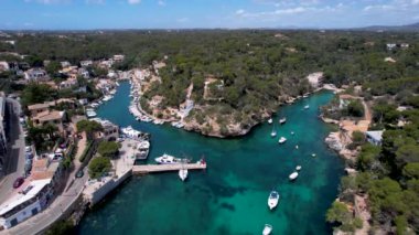 4K Hava Aracı, küçük bir balıkçı kasabasının videosu, kristal berrak turkuaz suyu olan balıkçı tekneleri, Cala Figuera, Mallorca