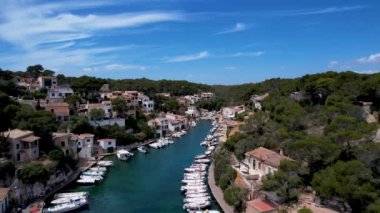 4K Hava Aracı, küçük bir balıkçı kasabasının videosu, kristal berrak turkuaz suyu olan balıkçı tekneleri, Cala Figuera, Mallorca
