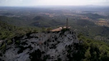 4K Hava Aracı video destansı heykel, tepenin üstünde çapraz ve manastır güneşli bir günde, Sant Salvador Sığınak ve Puig, Mallorca