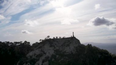 4K Hava Aracı video destansı heykel, tepenin üstünde çapraz ve manastır güneşli bir günde, Sant Salvador Sığınak ve Puig, Mallorca