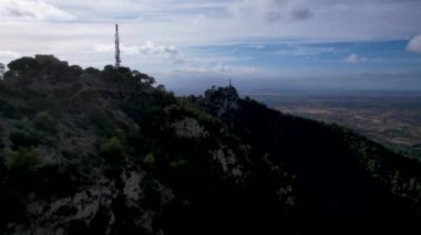 4K Hava Aracı video destansı heykel, tepenin üstünde çapraz ve manastır güneşli bir günde, Sant Salvador Sığınak ve Puig, Mallorca