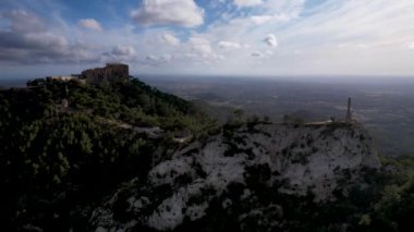 4K Hava Aracı video destansı heykel, tepenin üstünde çapraz ve manastır güneşli bir günde, Sant Salvador Sığınak ve Puig, Mallorca