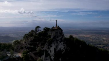 4K Hava Aracı video destansı heykel, tepenin üstünde çapraz ve manastır güneşli bir günde, Sant Salvador Sığınak ve Puig, Mallorca