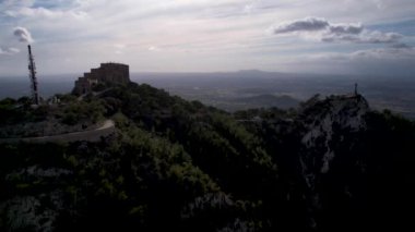 4K Hava Aracı video destansı heykel, tepenin üstünde çapraz ve manastır güneşli bir günde, Sant Salvador Sığınak ve Puig, Mallorca