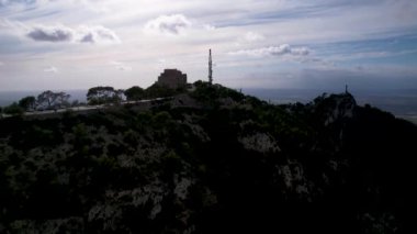 4K Hava Aracı video destansı heykel, tepenin üstünde çapraz ve manastır güneşli bir günde, Sant Salvador Sığınak ve Puig, Mallorca
