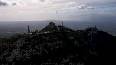 4K Hava Aracı video destansı heykel, tepenin üstünde çapraz ve manastır güneşli bir günde, Sant Salvador Sığınak ve Puig, Mallorca