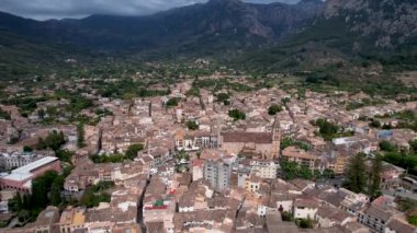 4K Hava Aracı, çevredeki dağlara yerleşmiş deniz manzaralı terasotta evleri ve merkezde tren Soller, Mallorca ile birlikte bir katedrali olan sihirli bir kasabanın videosu.