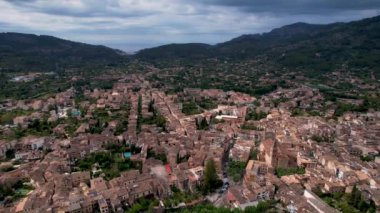 4K Hava Aracı, çevredeki dağlara yerleşmiş deniz manzaralı terasotta evleri ve merkezde tren Soller, Mallorca ile birlikte bir katedrali olan sihirli bir kasabanın videosu.