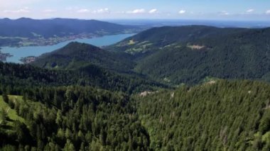 Güneşli bir günde Bavyera 'daki güzel Alpler sıradağlarının 4K hava aracı videosu. Arka planda Tegernsee Gölü olan Baumgartenschneid tepesi.