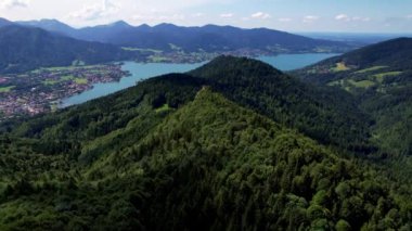 Güneşli bir günde Bavyera 'daki güzel Alpler sıradağlarının 4K hava aracı videosu. Arka planda Tegernsee Gölü olan Baumgartenschneid tepesi.