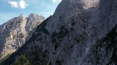 4K Hava Aracı, Tirol Avusturya 'da mavi gökyüzü ile güneşli bir yaz gününde belirgin zirveleri olan Kaiserbachtal kayalık gri dağların videosu