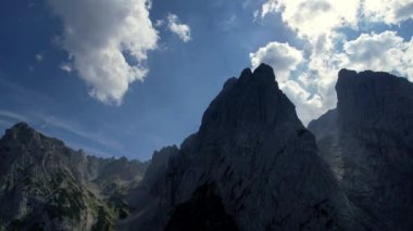 4K Hava Aracı, Tirol Avusturya 'da mavi gökyüzü ile güneşli bir yaz gününde belirgin zirveleri olan Kaiserbachtal kayalık gri dağların videosu