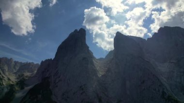 4K Hava Aracı, Tirol Avusturya 'da mavi gökyüzü ile güneşli bir yaz gününde belirgin zirveleri olan Kaiserbachtal kayalık gri dağların videosu