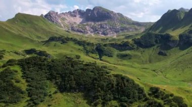 4K Hava Aracı Schrecksee Dağı 'nın en güzel dağ gölünün videosu Bavyera Alpleri' nde güneşli bir günde yemyeşil çimlerle beslenen ineklerle mavi gökyüzü ve etrafındaki kayalık tepelerle çevrili.