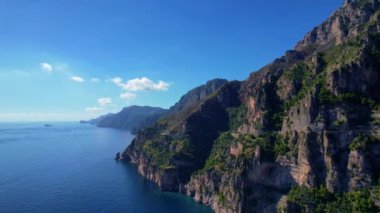 4K Hava Aracı, güneşli bir günde, Positano, İtalya 'nın ünlü Amalfi kıyılarında, çevresindeki dağlarda renkli evler ve deniz manzaralı sihirli bir kasabanın videosu.