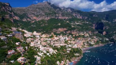 4K Hava Aracı, güneşli bir günde, Positano, İtalya 'nın ünlü Amalfi kıyılarında, çevresindeki dağlarda renkli evler ve deniz manzaralı sihirli bir kasabanın videosu.