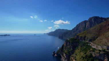 4K Hava Aracı, güneşli bir günde, Positano, İtalya 'nın ünlü Amalfi kıyılarında, çevresindeki dağlarda renkli evler ve deniz manzaralı sihirli bir kasabanın videosu.