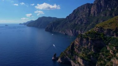 4K Hava Aracı, güneşli bir günde, Positano, İtalya 'nın ünlü Amalfi kıyılarında, çevresindeki dağlarda renkli evler ve deniz manzaralı sihirli bir kasabanın videosu.