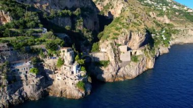 Güneşli bir günde, dar kayalıklarda eşsiz bir köprünün 4K hava manzarası. İtalya 'nın pitoresk Amalfi kıyısındaki ünlü turistik eğlence merkezi Fiordo di Furore