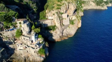 Güneşli bir günde, dar kayalıklarda eşsiz bir köprünün 4K hava manzarası. İtalya 'nın pitoresk Amalfi kıyısındaki ünlü turistik eğlence merkezi Fiordo di Furore