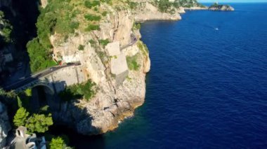 Güneşli bir günde, dar kayalıklarda eşsiz bir köprünün 4K hava manzarası. İtalya 'nın pitoresk Amalfi kıyısındaki ünlü turistik eğlence merkezi Fiordo di Furore