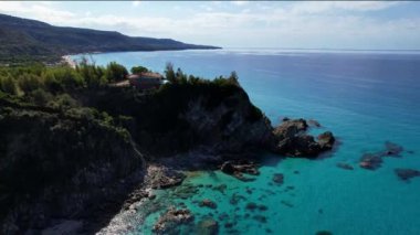 Dünyanın en güzel plajlarından birinin 4K Hava Aracı videosu. Turkuaz berrak mavi su ve güneşli bir yaz gününde büyük kayaları olan beyaz kum. Marinella di Zambrone Paradiso Tropea İtalya