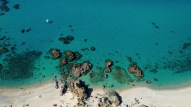 Dünyanın en güzel plajlarından birinin 4K Hava Aracı videosu. Turkuaz berrak mavi su ve güneşli bir yaz gününde büyük kayaları olan beyaz kum. Marinella di Zambrone Paradiso Tropea İtalya