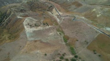 Tepenin tepesinde harabeler ve boş evler olan gizemli hayalet kasabanın 4K hava aracı videosu. Yıkılan yapıları ve yıkılan kilisesi olan lanetli bir köy. Terk edilmiş şehir Craco, Matera, İtalya