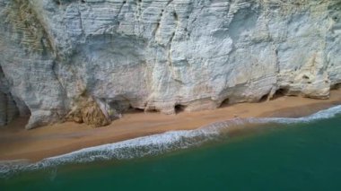 Güneşli bir günde, beyaz yüksek uçurumlar ve turkuaz mavi sularla çevrili en büyüleyici kumlu kumsalın 4K hava aracı videosu. İtalya, Apulia 'daki büyüleyici Vignanotica plajı