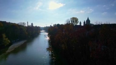 Münih şehir merkezinde güneşli bir günde Isar Nehri, Saint Lukas Kilisesi, Marienplatz ve Maximilianeum ile güzel bir sonbaharın 4K hava aracı videosu, Almanya