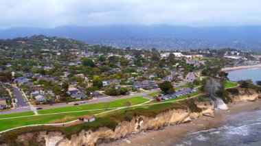 Dünyaca ünlü Santa Barbara 'nın, dramatik bir zemin olarak dağlara bakan hava manzarası. Batı Sahili California USA. Pasifik Okyanusu. Palmiye ağaçları olan kayalıklar ve yüzlerce teknesi olan büyük bir liman.