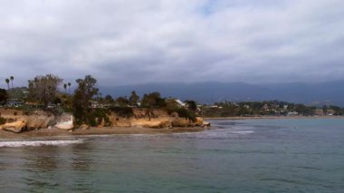 Dünyaca ünlü Santa Barbara 'nın, dramatik bir zemin olarak dağlara bakan hava manzarası. Batı Sahili California USA. Pasifik Okyanusu. Palmiye ağaçları olan kayalıklar ve yüzlerce teknesi olan büyük bir liman.