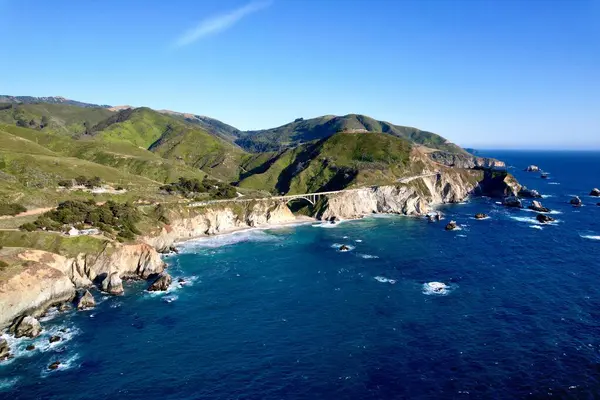 Bixby Creek Köprüsü 'nün Kaliforniya, Big Sur' daki Pasifik Sahil Otoyolu 'ndaki hava aracı görüntüleri. Altın saat boyunca 4K çözünürlüğünde yakalanan, ABD okyanus kayalıkları ile ikonik köprü
