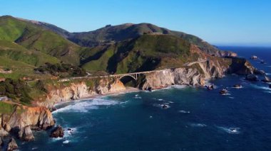 Bixby Creek Köprüsü 'nün Kaliforniya, Big Sur' daki Pasifik Sahil Otoyolu 'ndaki hava aracı görüntüleri. Altın saat boyunca 4K çözünürlüğünde yakalanan, ABD okyanus kayalıkları ile ikonik köprü