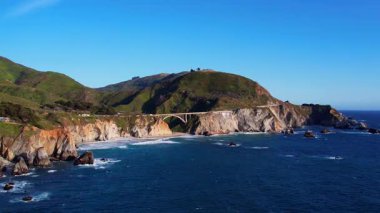 Bixby Creek Köprüsü 'nün Kaliforniya, Big Sur' daki Pasifik Sahil Otoyolu 'ndaki hava aracı görüntüleri. Altın saat boyunca 4K çözünürlüğünde yakalanan, ABD okyanus kayalıkları ile ikonik köprü