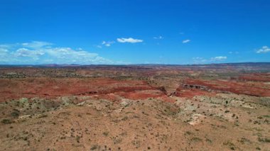 Utah Çölü 'nde nefes kesici kırmızı bir kanyonun 4K Hava Aracı videosu ve eyaletler arası yolda giden arabalar. Zeminin gerçek dışı renginde ve oyulmuş nehir yatağıyla görkemli bir manzara. Birleşik Devletler