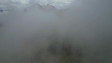 Almanya 'nın en yüksek dağ zirvesine yapılan yürüyüşün 4K Hava Aracı videosu, destansı bulutlar ve inanılmaz doğa ile kasvetli sisli bir günde Zugspitze. Ünlü dağ kulübesi Knorr Hut