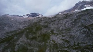 Almanya 'nın en yüksek dağ zirvesine yapılan yürüyüşün 4K Hava Aracı videosu, destansı bulutlar ve inanılmaz doğa ile kasvetli sisli bir günde Zugspitze. Ünlü dağ kulübesi Knorr Hut