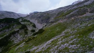Almanya 'nın en yüksek dağ zirvesine yapılan yürüyüşün 4K Hava Aracı videosu, destansı bulutlar ve inanılmaz doğa ile kasvetli sisli bir günde Zugspitze. Ünlü dağ kulübesi Knorr Hut