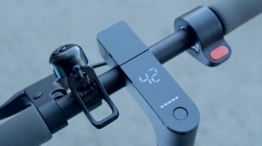 4K yakın çekim siyah direksiyon ve elektrikli scooter ekranın üst görüntüsü. Ekranda aracın akü şarj göstergesini ve şarj yüzdesini görebilirsiniz.