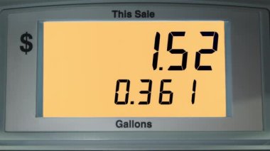 4K görüntüler turuncu ekran ve benzin fiyatları ABD doları. Yakıt tanka girerken ekranda galon başına düşen fiyat artışı. Benzin pompası, benzin istasyonunda.. 