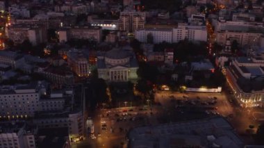 4K yüksek kaliteli hava görüntüsü. Rumen Atene, Bükreş şehir merkezindeki konser salonu. Romanya başkentinin manzarası. Gece şehir ışıkları gün batımından sonra. Avrupa 'nın güzel tarihi şehri. 