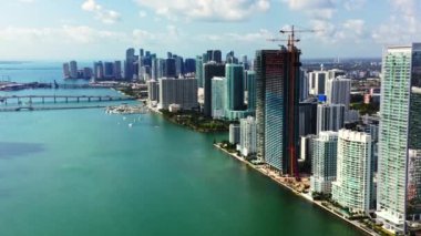 Miami şehir merkezinin 4K hava görüntüleri. Şehir merkezinin güzel şehir manzarası. Mavi, yeşil Biscayne Körfezi manzaralı. Yerleşim yeri ön cephe binaları. Gökyüzü bulutlu bir metropolün arka planında